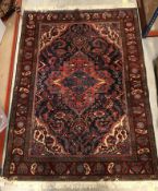 An Oriental carpet, the central panel set with foliate decorated medallion on a red and blue