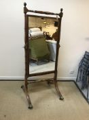 A Regency mahogany and rosewood strung cheval mirror, the rectangular plate within a reeded frame on