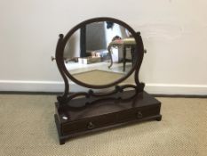 An Edwardian mahogany toilet mirror with oval satinwood strung plate on scroll supports to the two