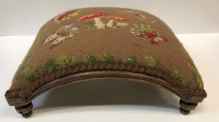 A pair of Victorian needlework upholstered stools, of crescent form, raised on circular feet, one