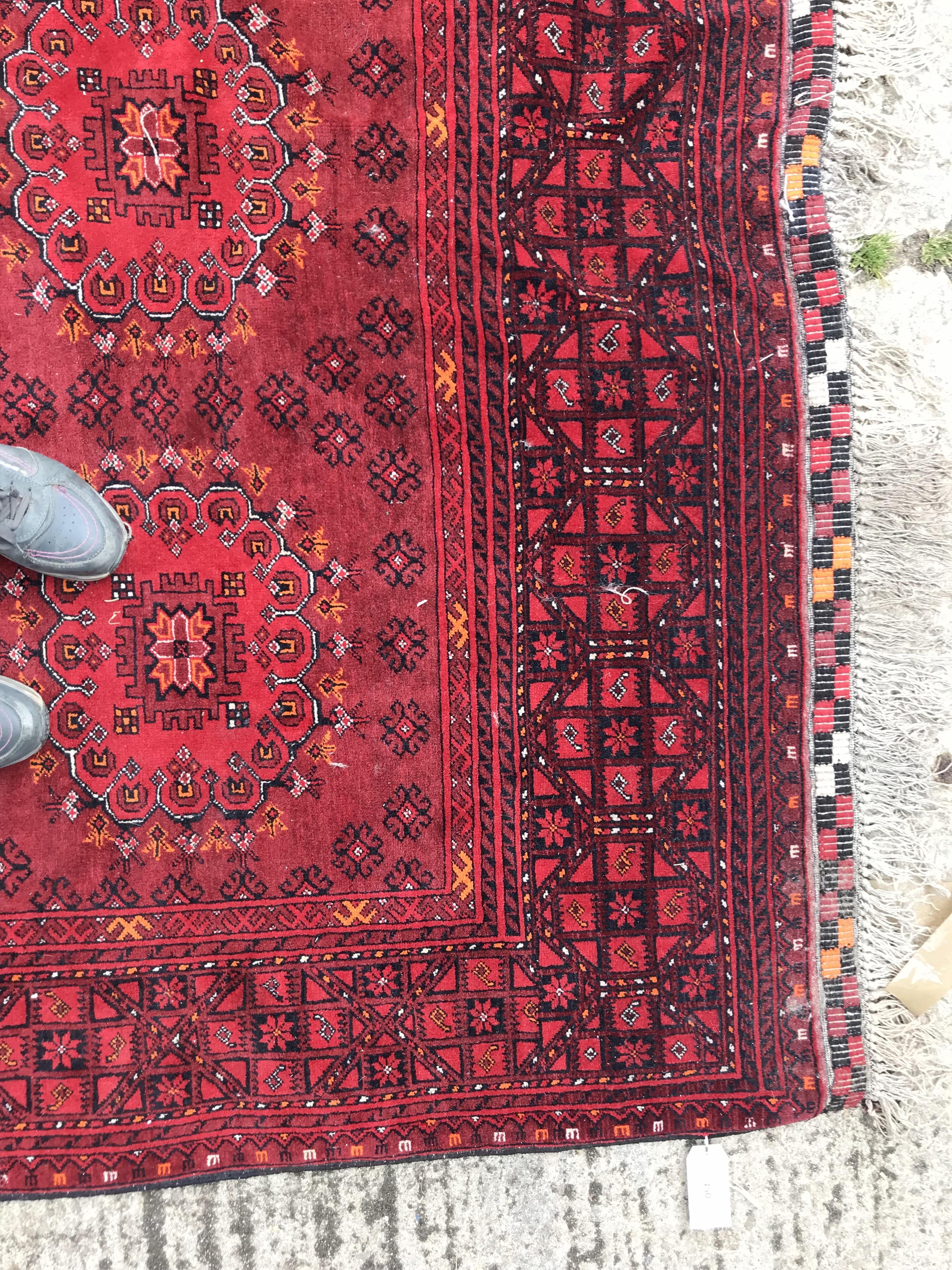 A Bokhara rug with repeating medallions on a red ground, within a red and black stepped geometric - Image 4 of 4