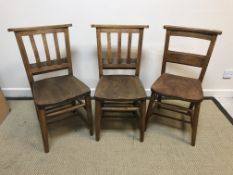 A pair of oak chapel chairs, together with another similar