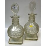 A pair of 19th Century cut glass decanters of onion form with faceted three collar neck and pear