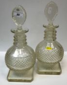 A pair of 19th Century cut glass decanters of onion form with faceted three collar neck and pear