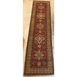 A modern Persian runner, the central panel set with repeating medallions on a red floral decorated