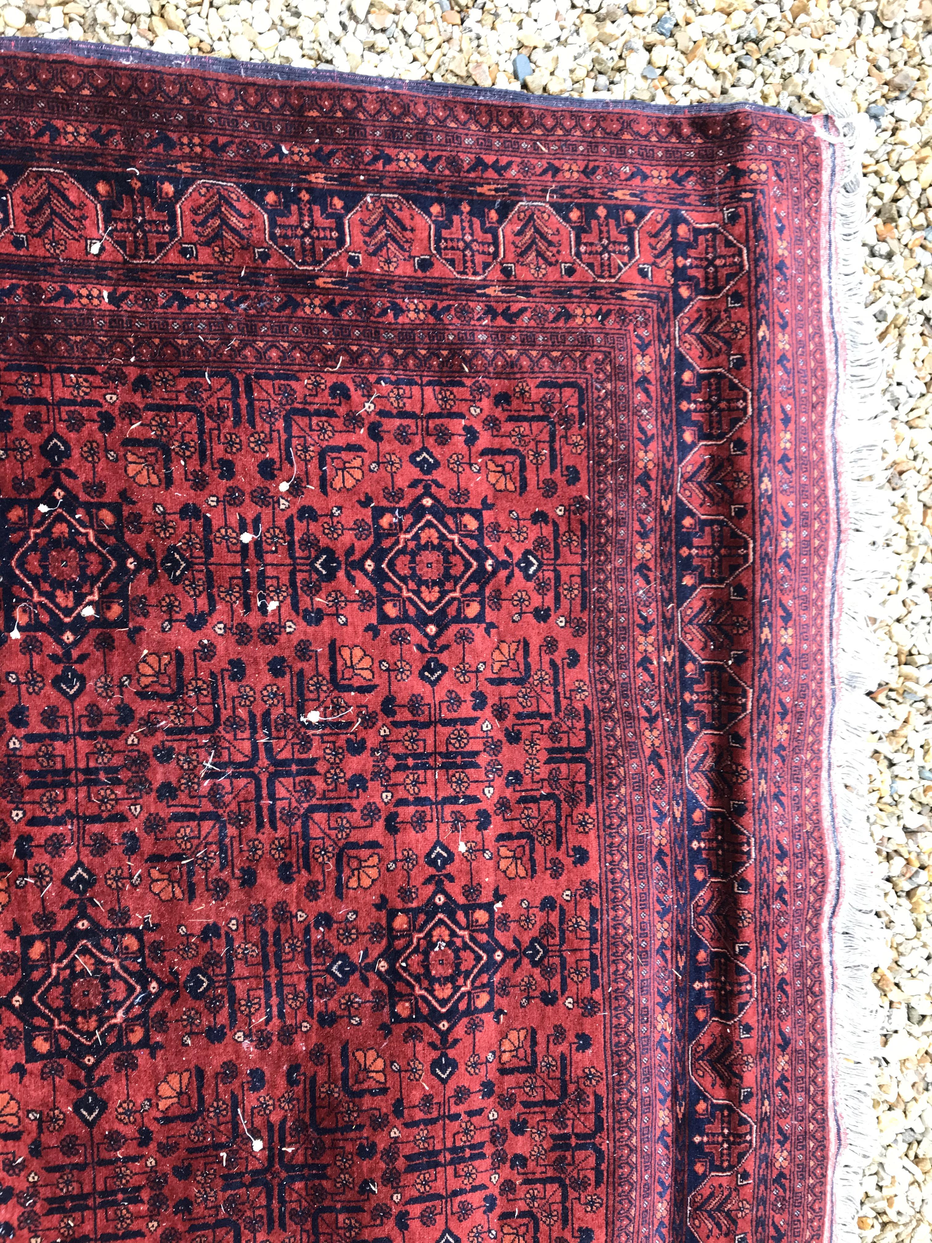 A Bokhara type carpet, the central panel set with repeating medallions on a dark red and black - Image 18 of 23