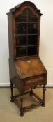 An early 20th Century walnut bureau bookcase in the 18th Century manner, the domed top over a glazed