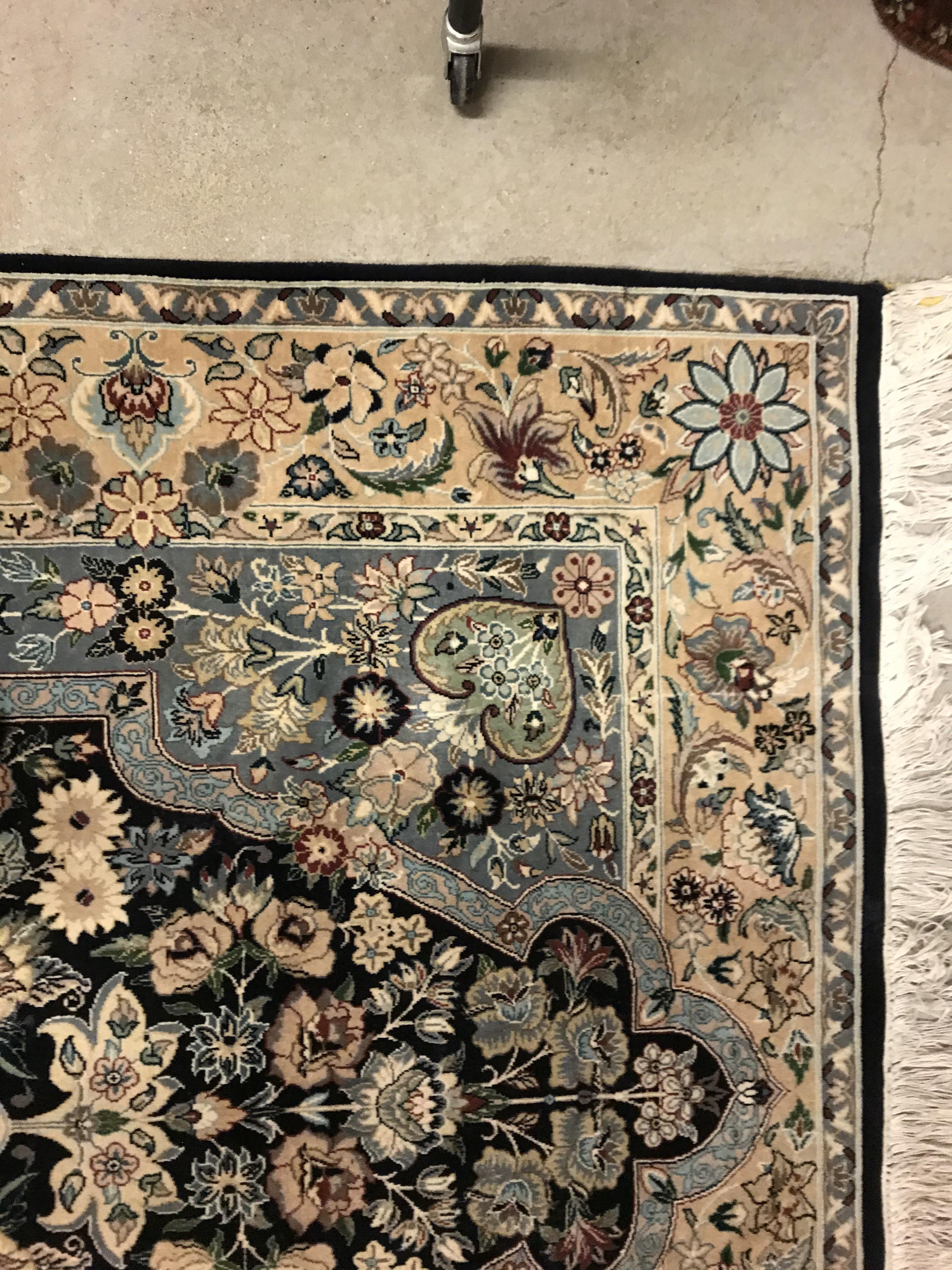 A Persian rug, the central panel set with floral decorated oval medallion on a dark blue and pale - Image 9 of 10