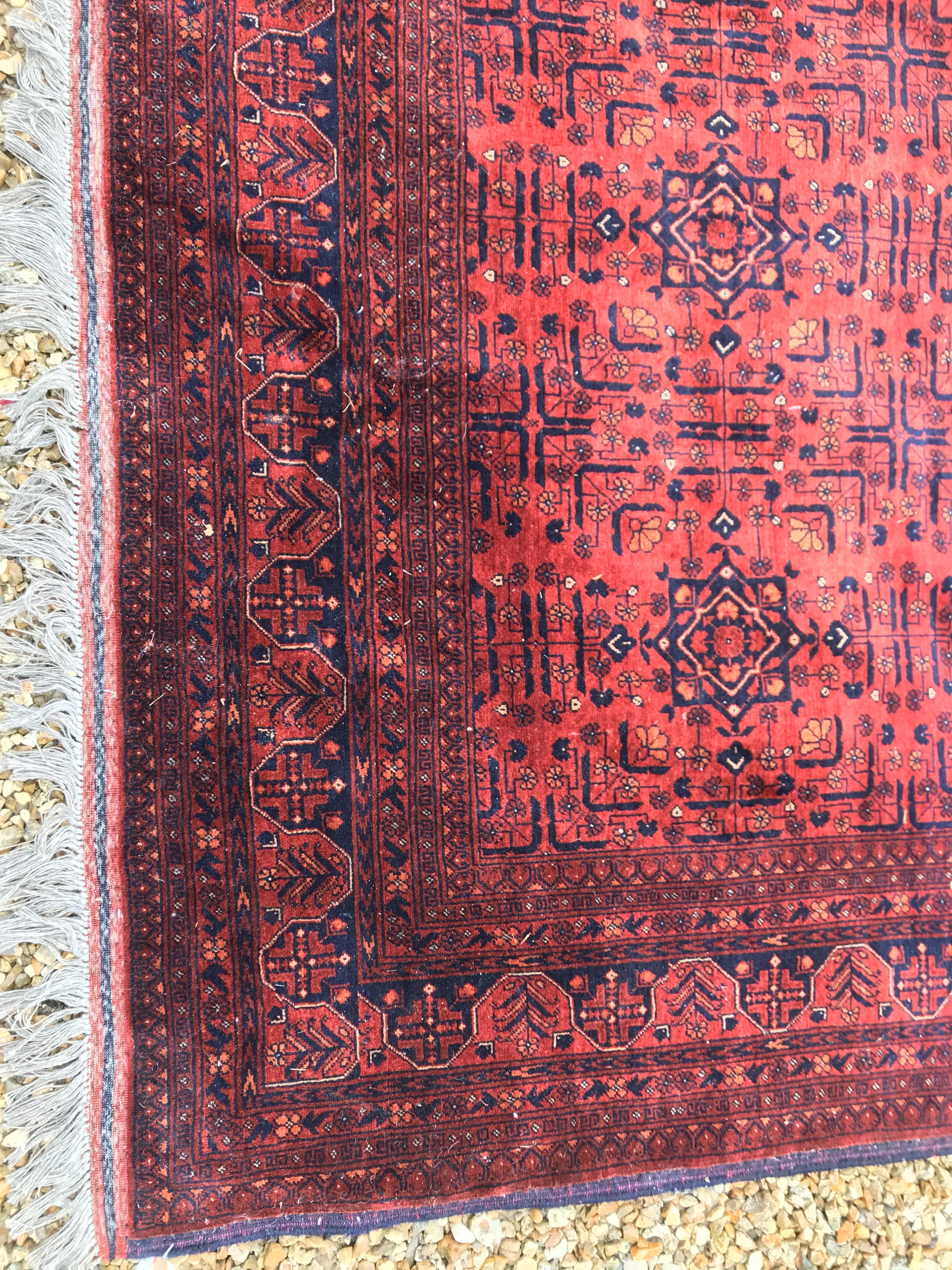 A Bokhara type carpet, the central panel set with repeating medallions on a dark red and black - Image 4 of 23