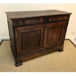 A 19th Century Italian oak side cabinet with plain top and moulded edge over two slim drawers with