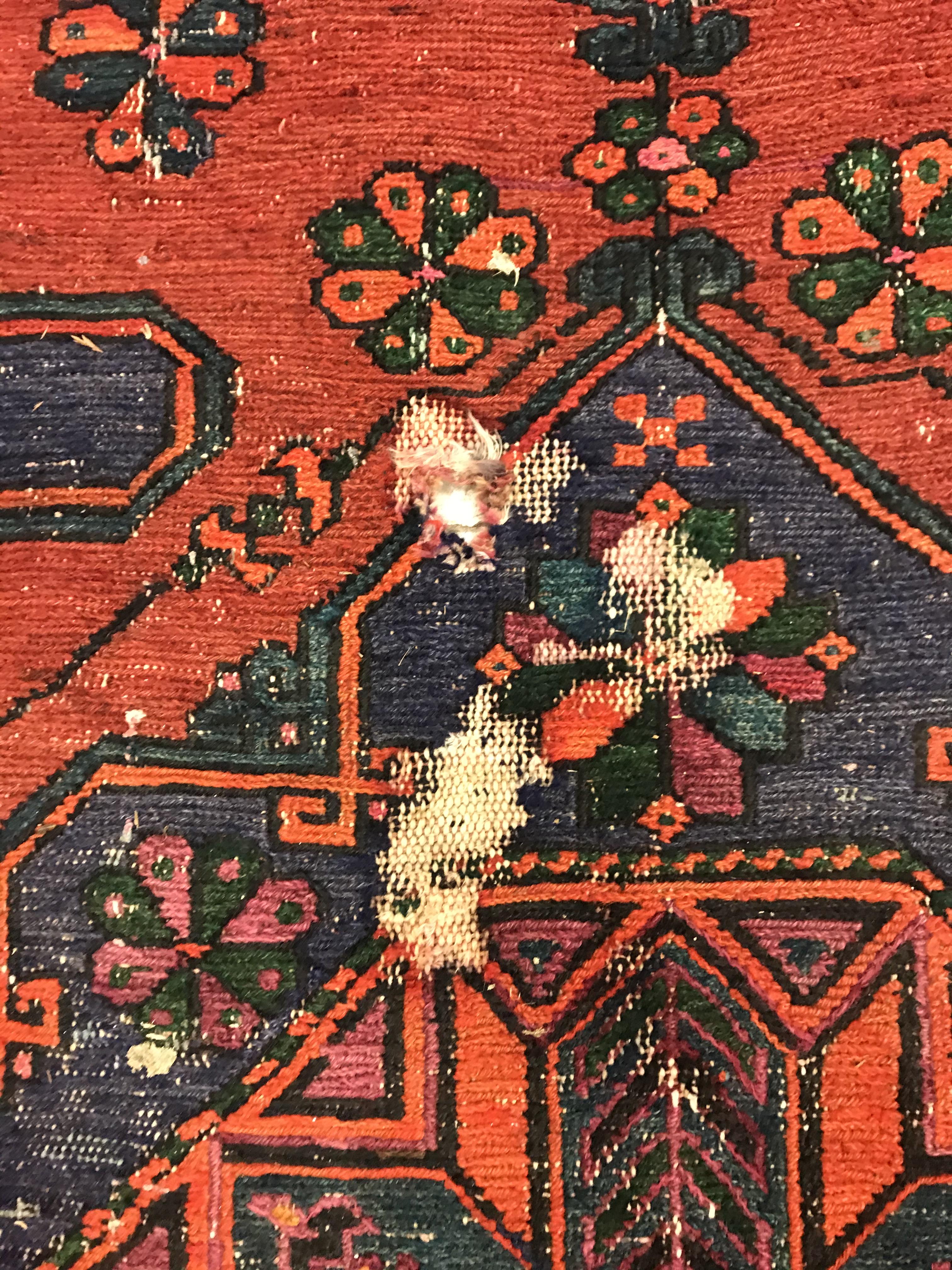 A Persian rug with three repeating lozenge medallions on a red and blue ground, within a blue, red - Image 14 of 20