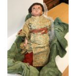 A late 19th / early 20th Century Japanese composition doll with flesh colour painted face and real