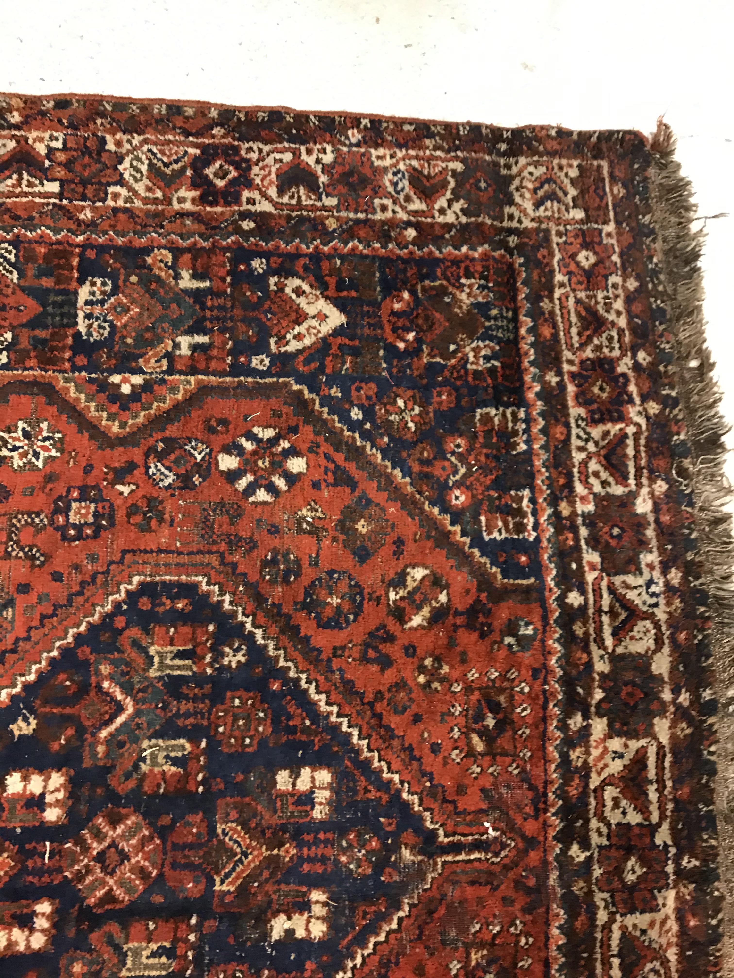 A Shiraz carpet, the central panel set with three joined diamond shaped medallions on a red and blue - Image 7 of 17