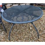 A grey metal circular garden table and four chairs, together with a Carambole Blooma garden parasol,