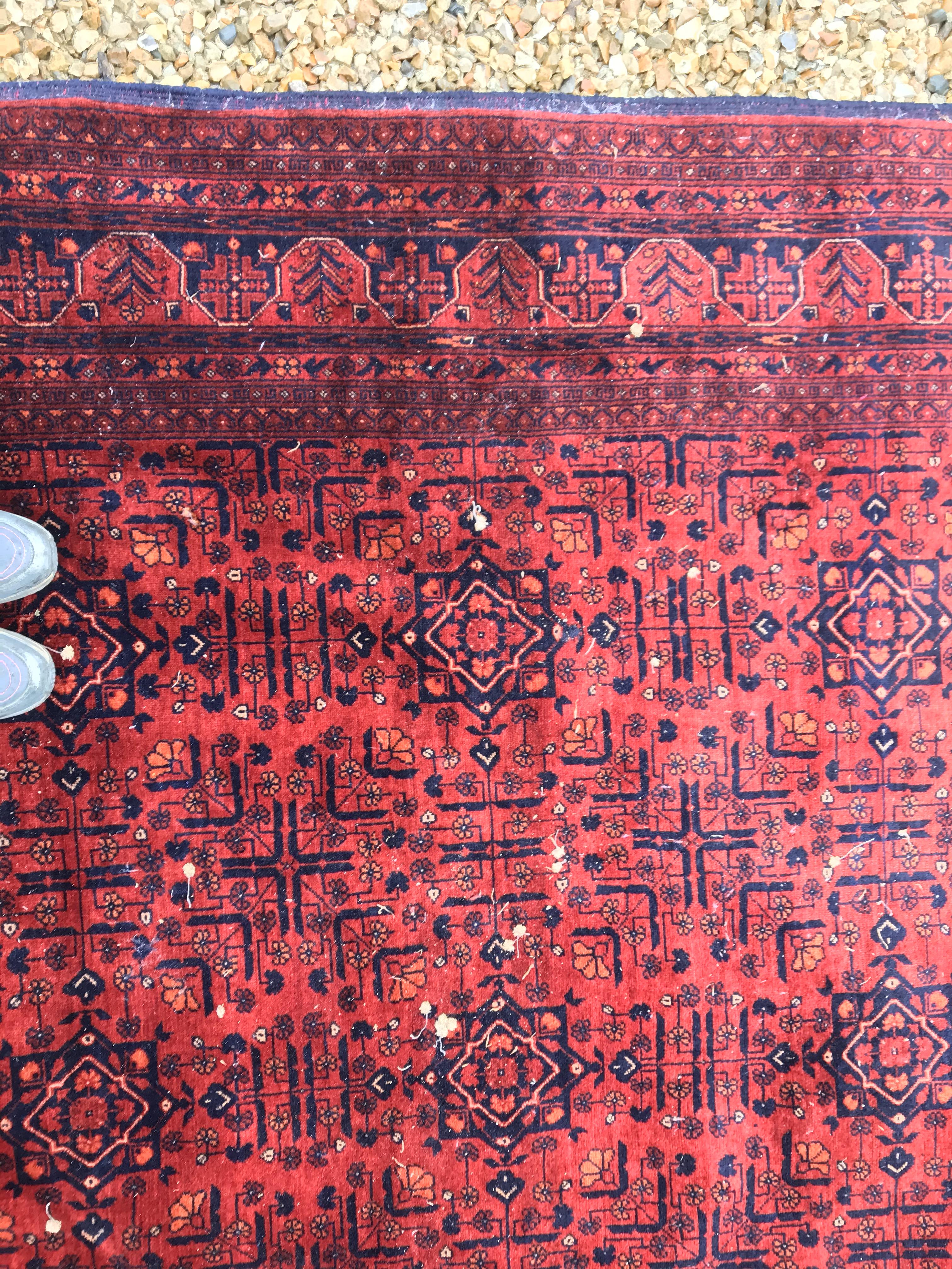 A Bokhara type carpet, the central panel set with repeating medallions on a dark red and black - Image 8 of 23