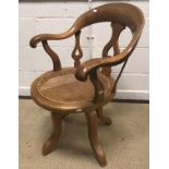 A Victorian oak cane seated swivel office chair with yoke back, 84 cm high, together with a 19th