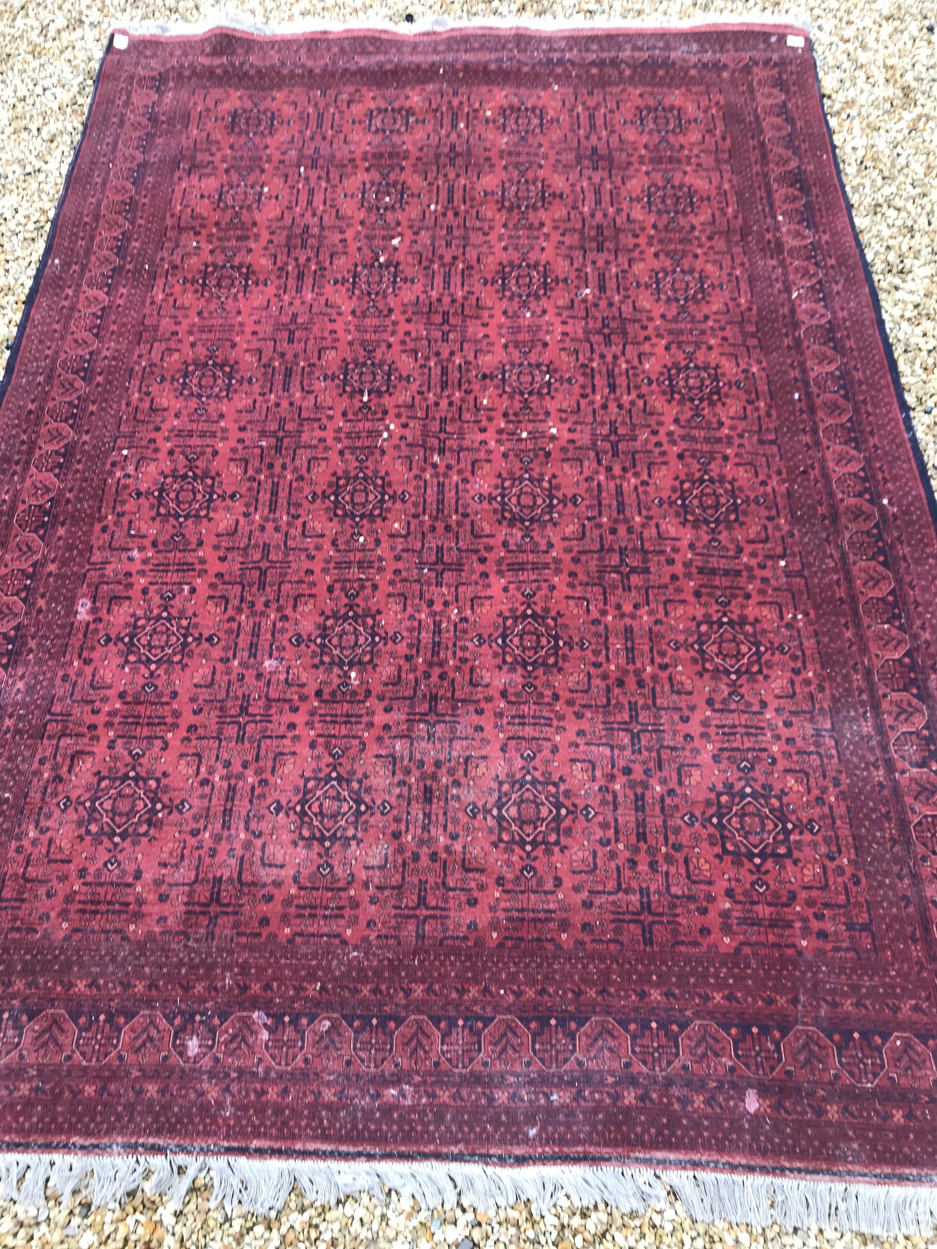 A Bokhara type carpet, the central panel set with repeating medallions on a dark red and black - Image 22 of 23