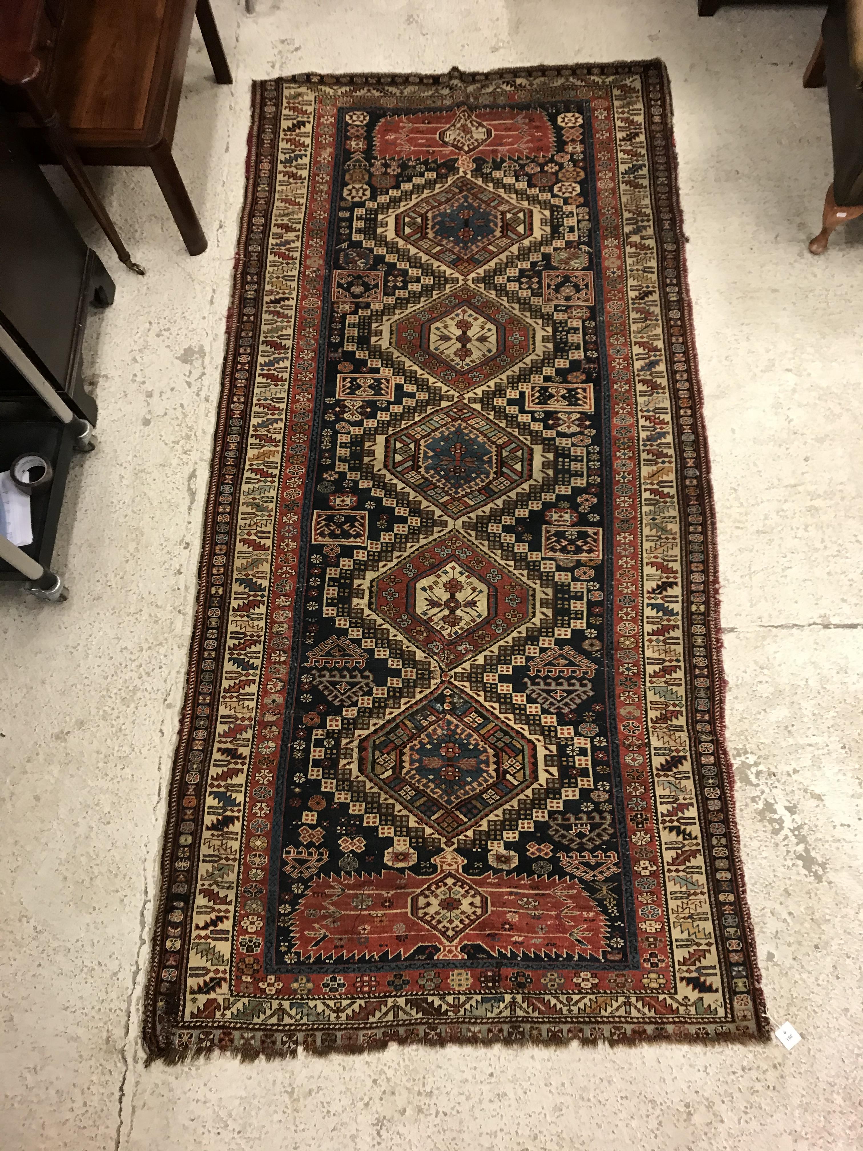 A fine Shirvan runner, the central panel set with repeating medallions on a dark blue stylised