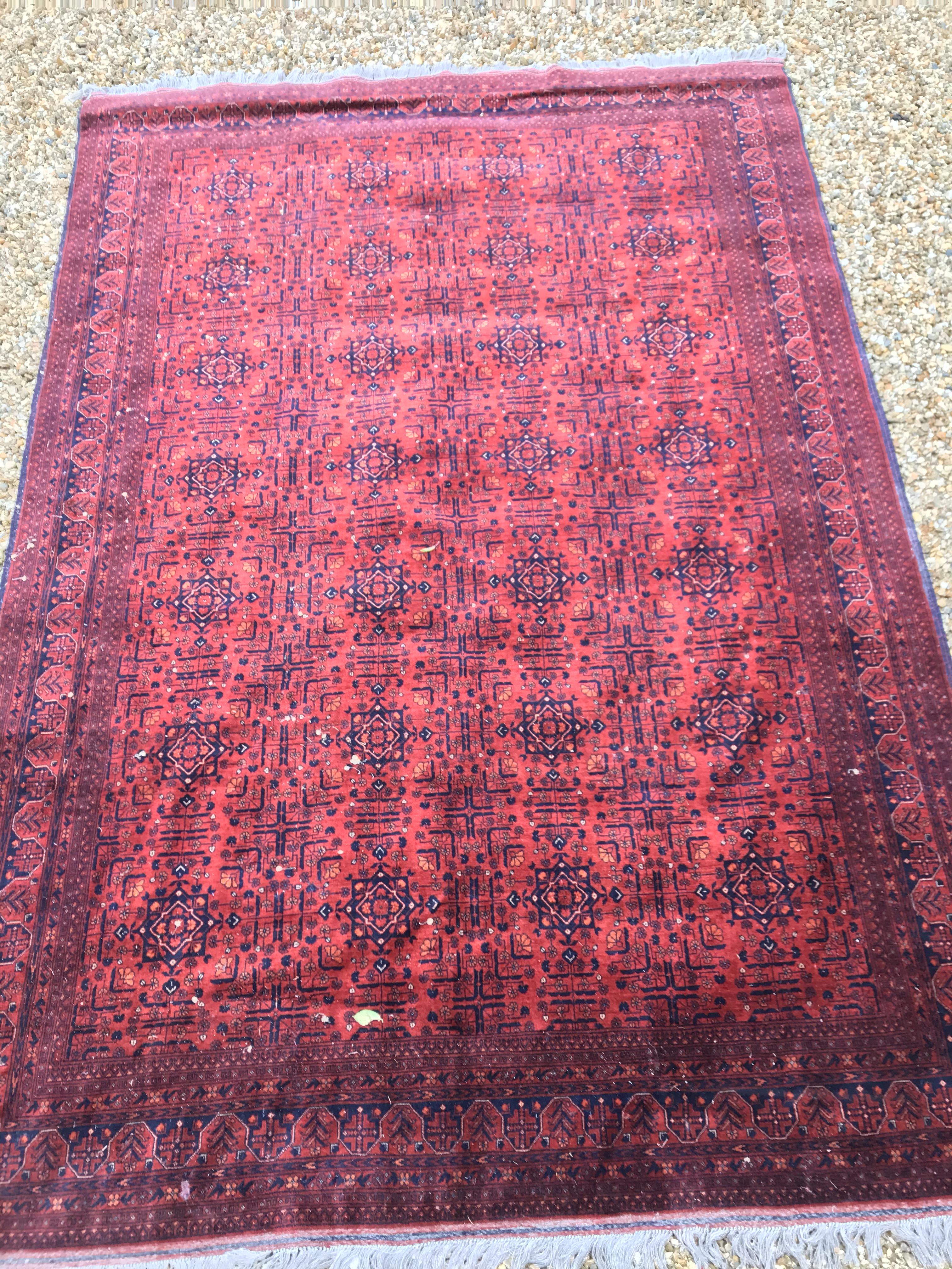A Bokhara type carpet, the central panel set with repeating medallions on a dark red and black