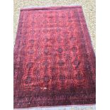 A Bokhara type carpet, the central panel set with repeating medallions on a dark red and black