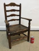 A 19th Century child's ash and elm panel seat ladder back elbow chair on turned legs united by
