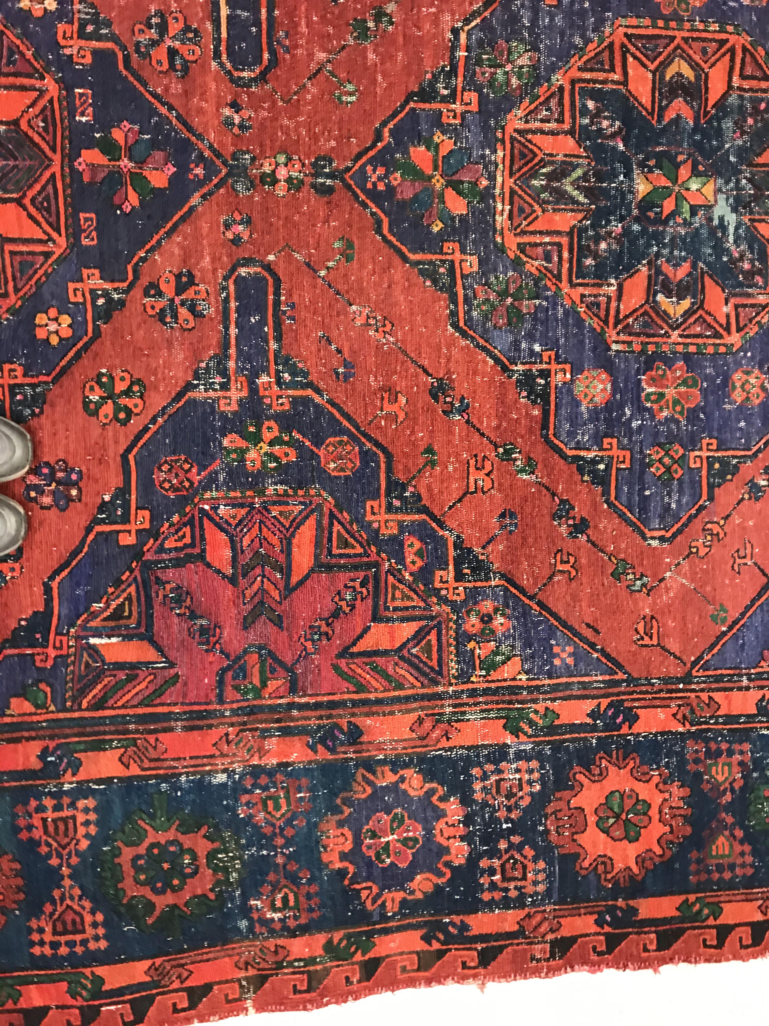 A Persian rug with three repeating lozenge medallions on a red and blue ground, within a blue, red - Image 6 of 20