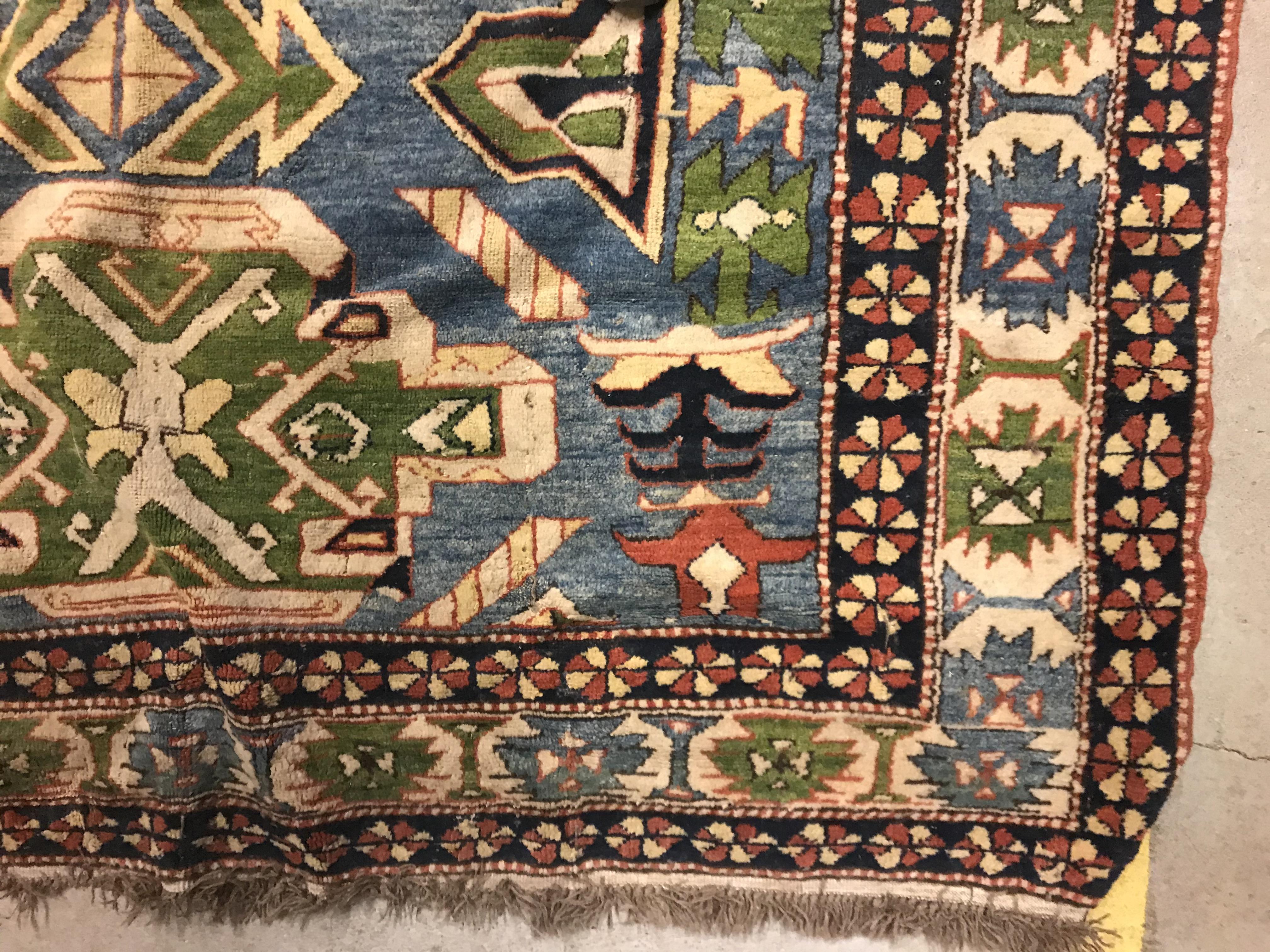 A Caucasian rug, the central panel set with three repeating medallions on a pale blue ground, within - Image 9 of 33