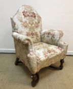 A circa 1900 upholstered scroll arm chair in the 17th Century style, raised on turned cup and