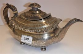 A George III silver teapot of rounded rectangular bellied form, the rim with gadrooned and foliate