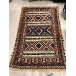 A Persian rug with striped geometric style decoration in blue, red, cream and orange, approx 200