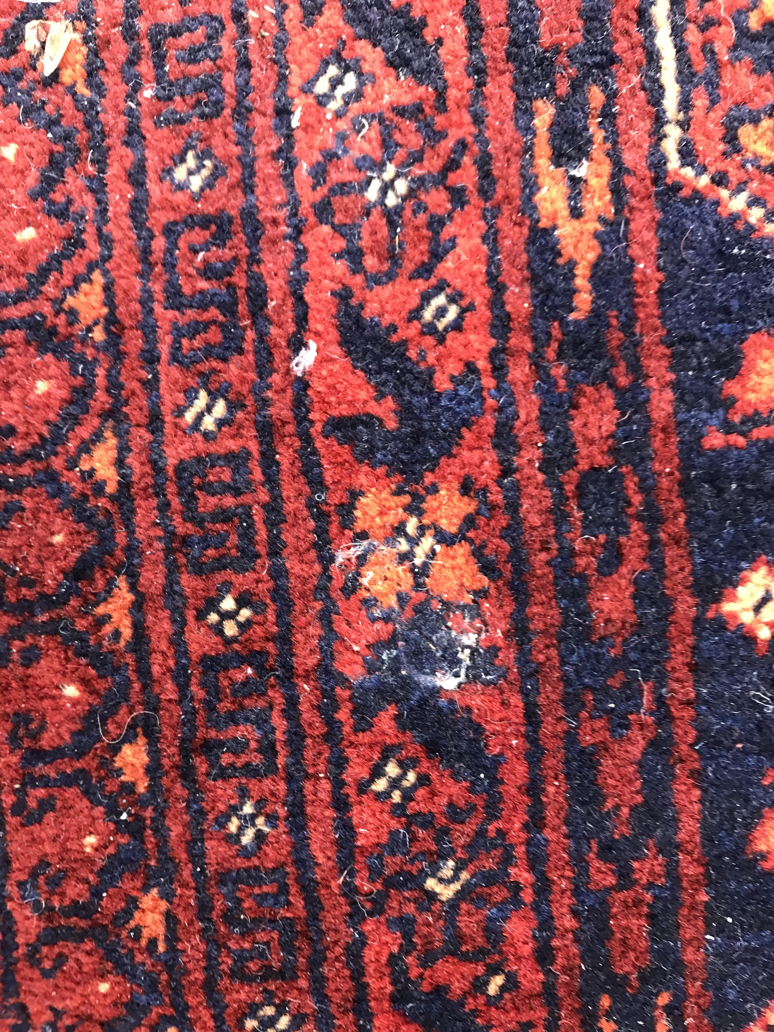 A Bokhara type carpet, the central panel set with repeating medallions on a dark red and black - Image 21 of 23