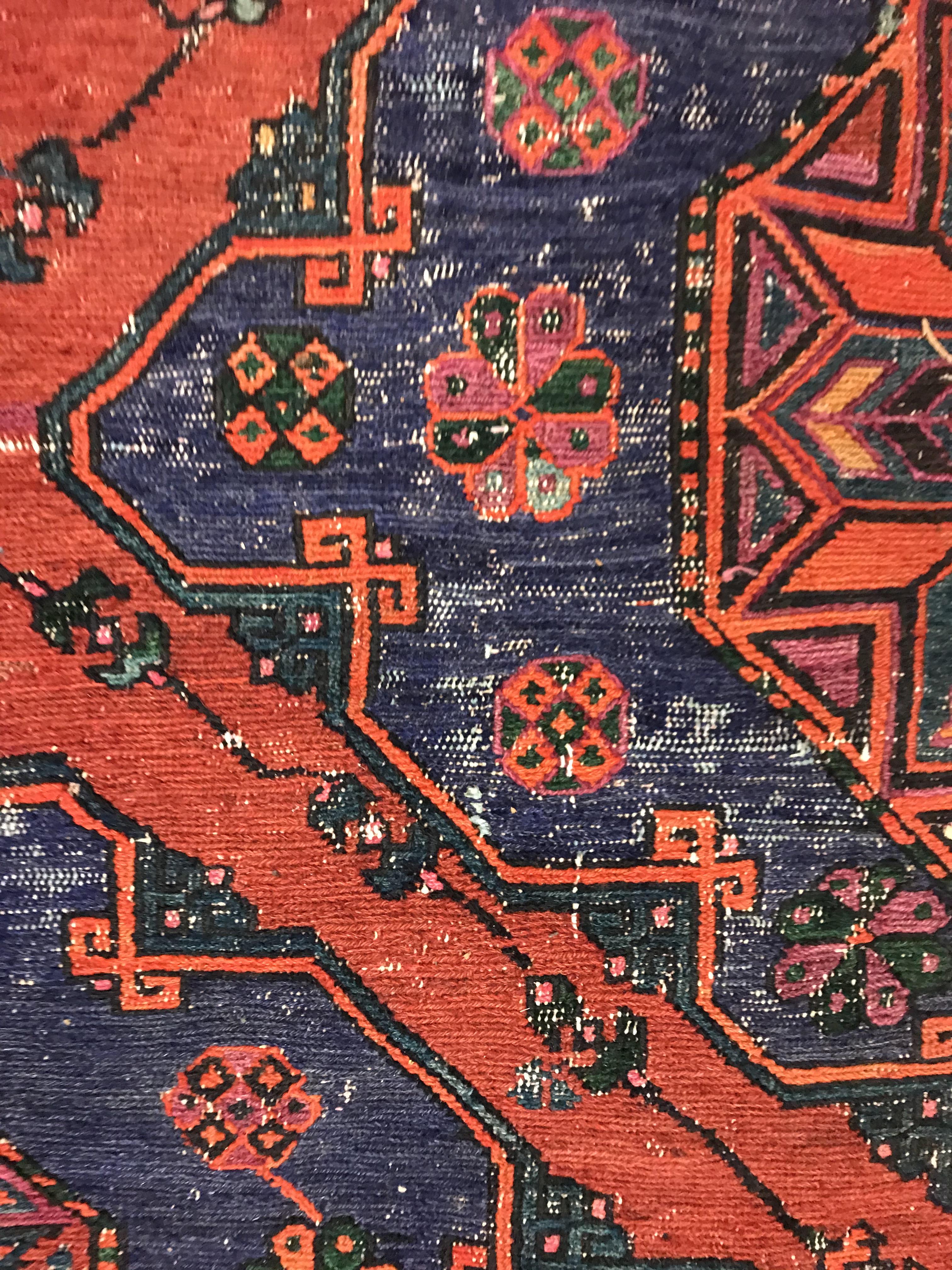 A Persian rug with three repeating lozenge medallions on a red and blue ground, within a blue, red - Image 16 of 20