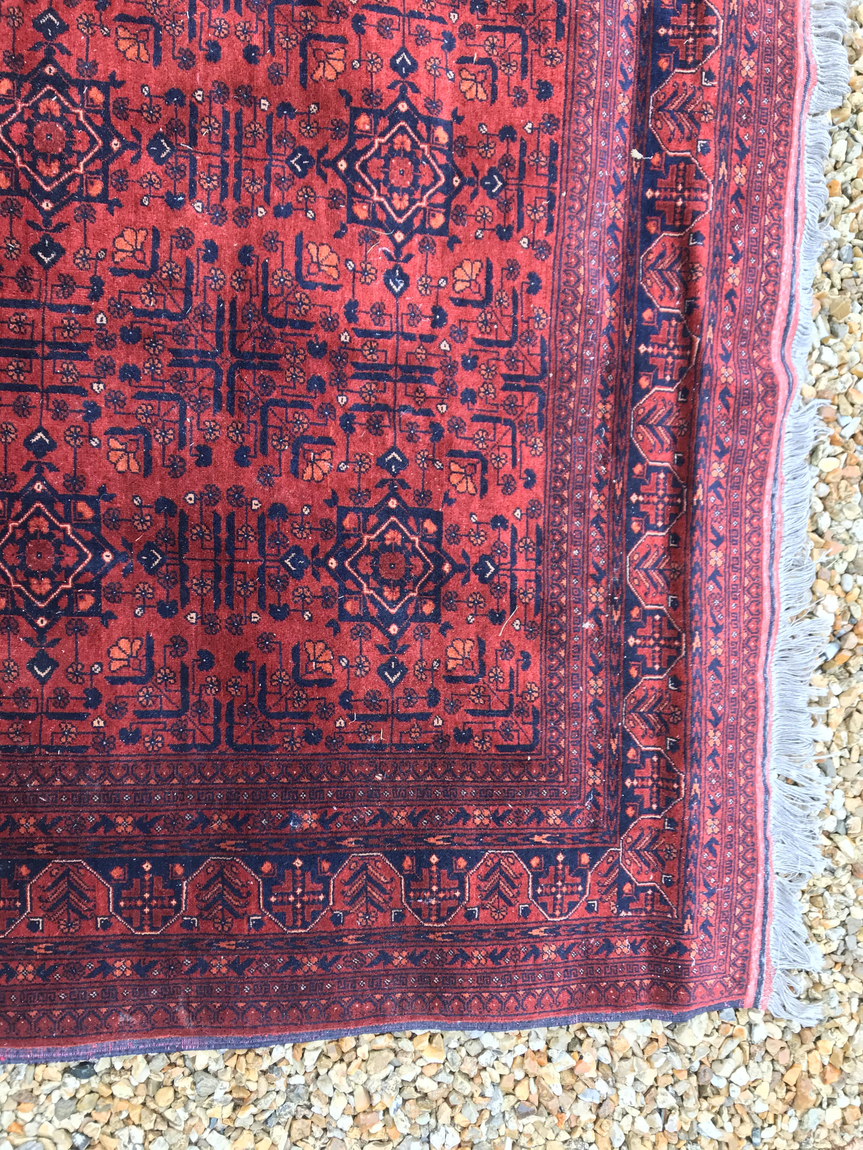 A Bokhara type carpet, the central panel set with repeating medallions on a dark red and black - Image 17 of 23