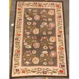 A Kelim rug, the central panel set with floral sprays on a mushroom ground, within a stepped border,