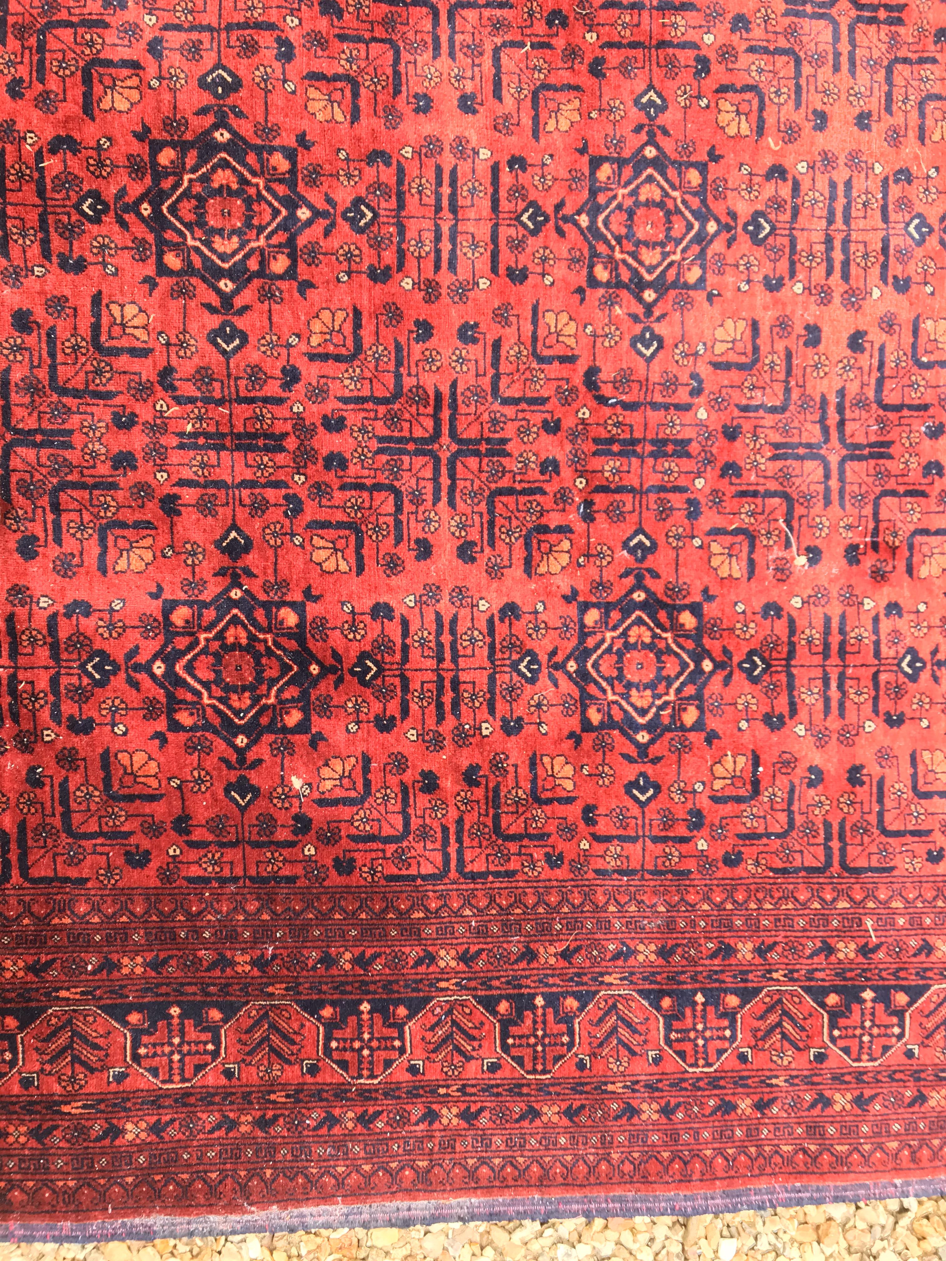 A Bokhara type carpet, the central panel set with repeating medallions on a dark red and black - Image 11 of 23