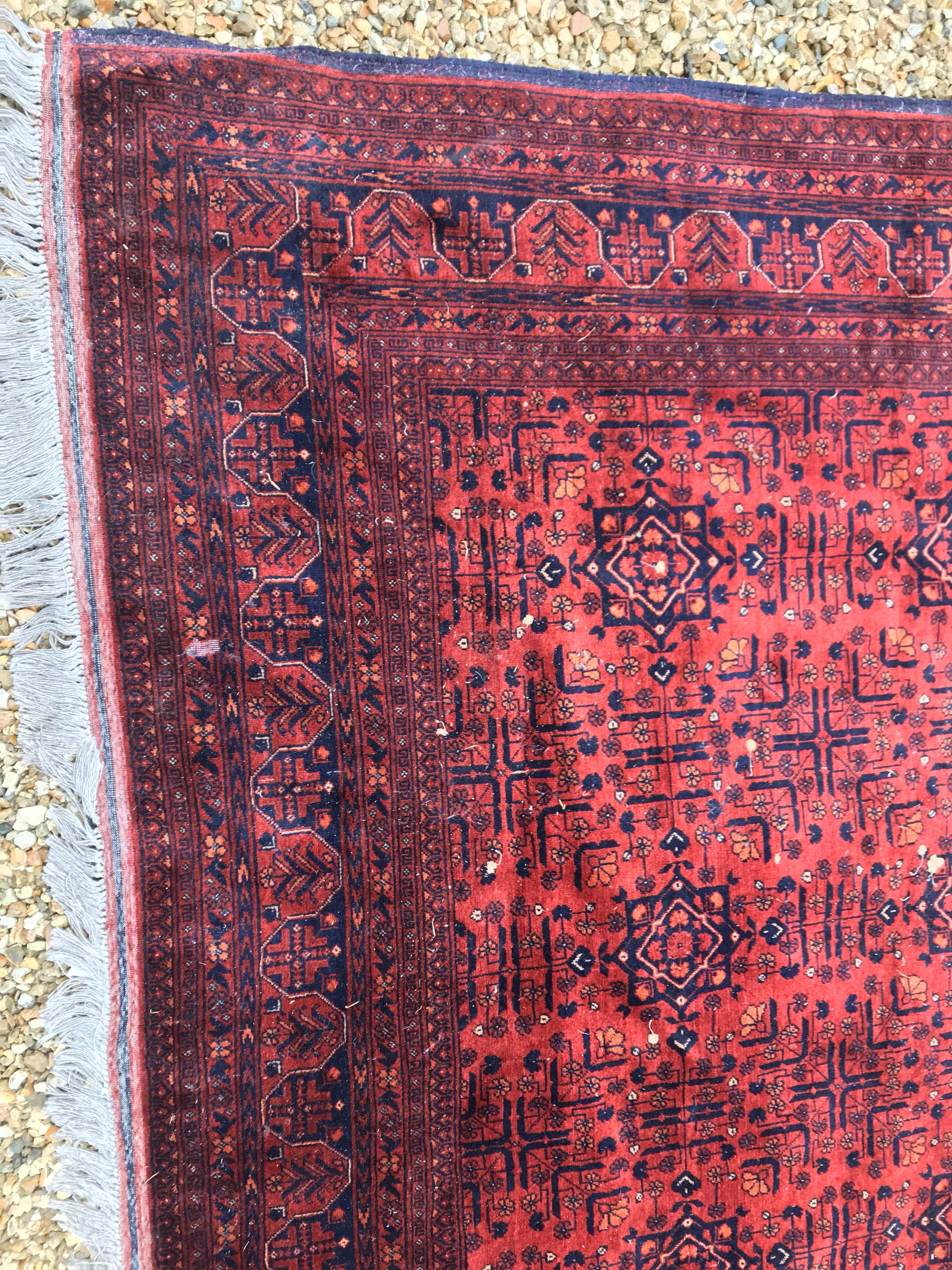 A Bokhara type carpet, the central panel set with repeating medallions on a dark red and black - Image 6 of 23