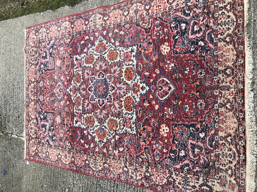 A Caucasian carpet, the central panel set with a flower head medallion on a red ground, with all