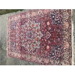 A Caucasian carpet, the central panel set with a flower head medallion on a red ground, with all