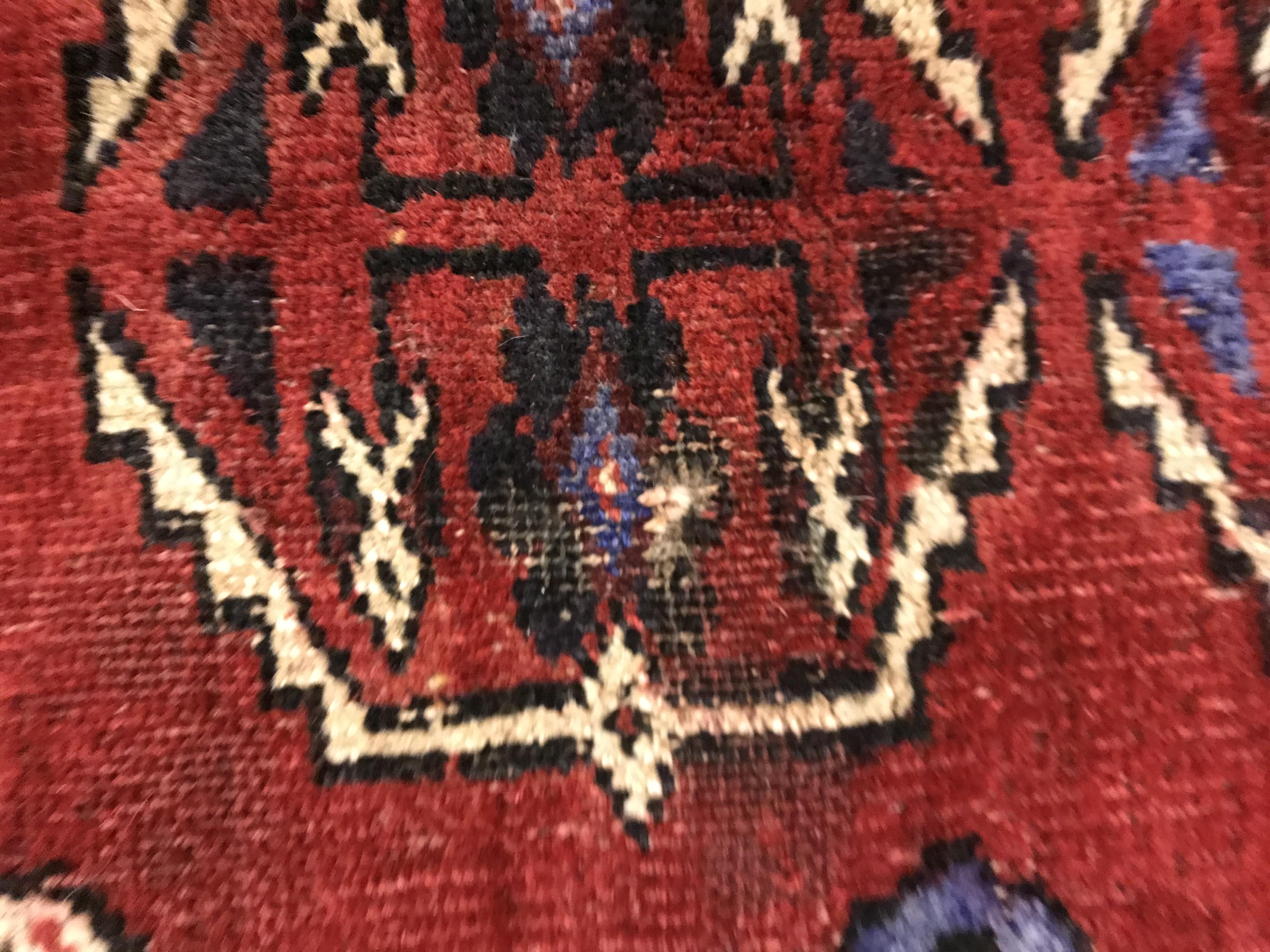 A Caucasian carpet, the central panel set with repeating medallion decoration on a blood red - Image 10 of 15