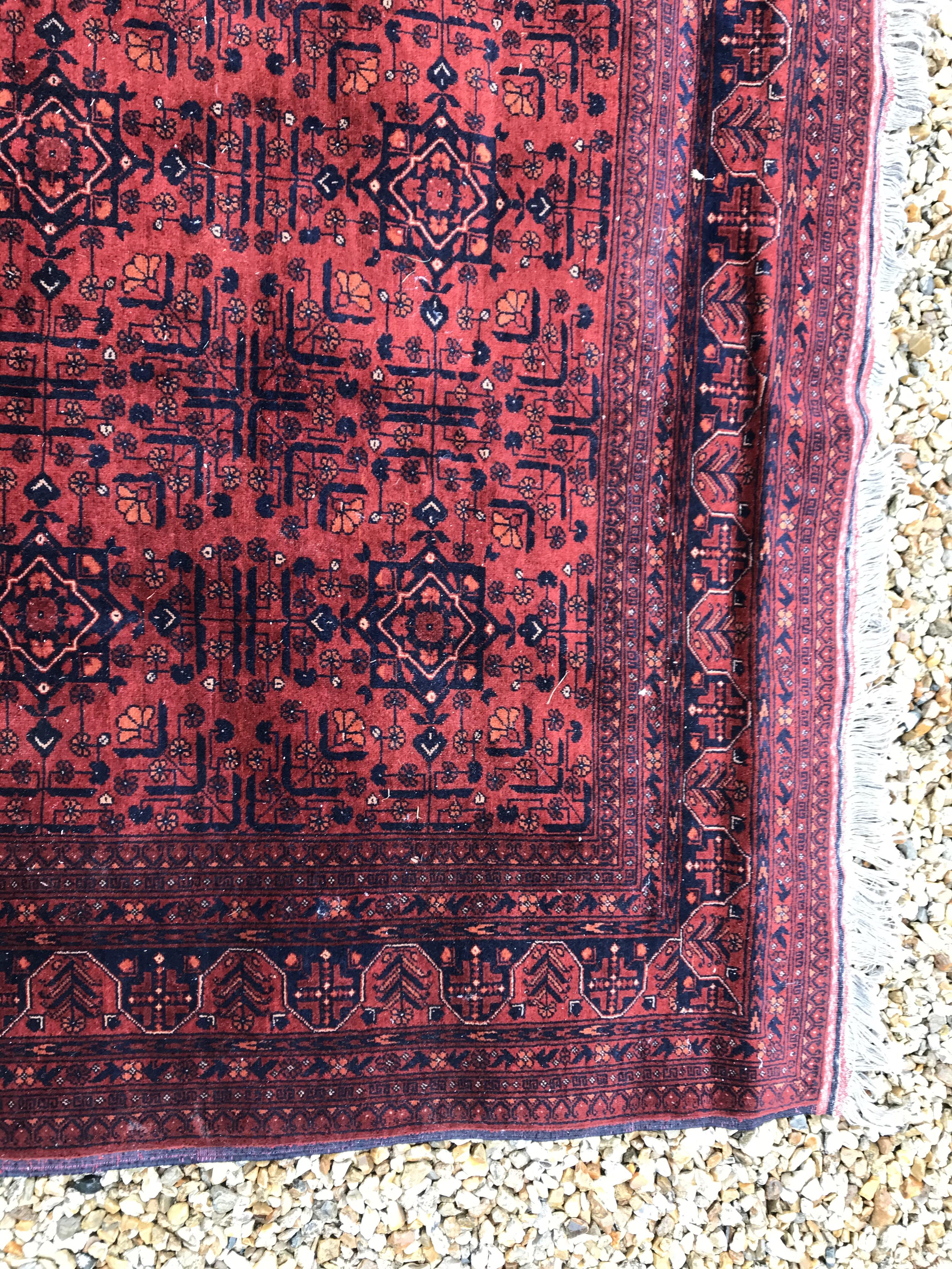 A Bokhara type carpet, the central panel set with repeating medallions on a dark red and black - Image 16 of 23