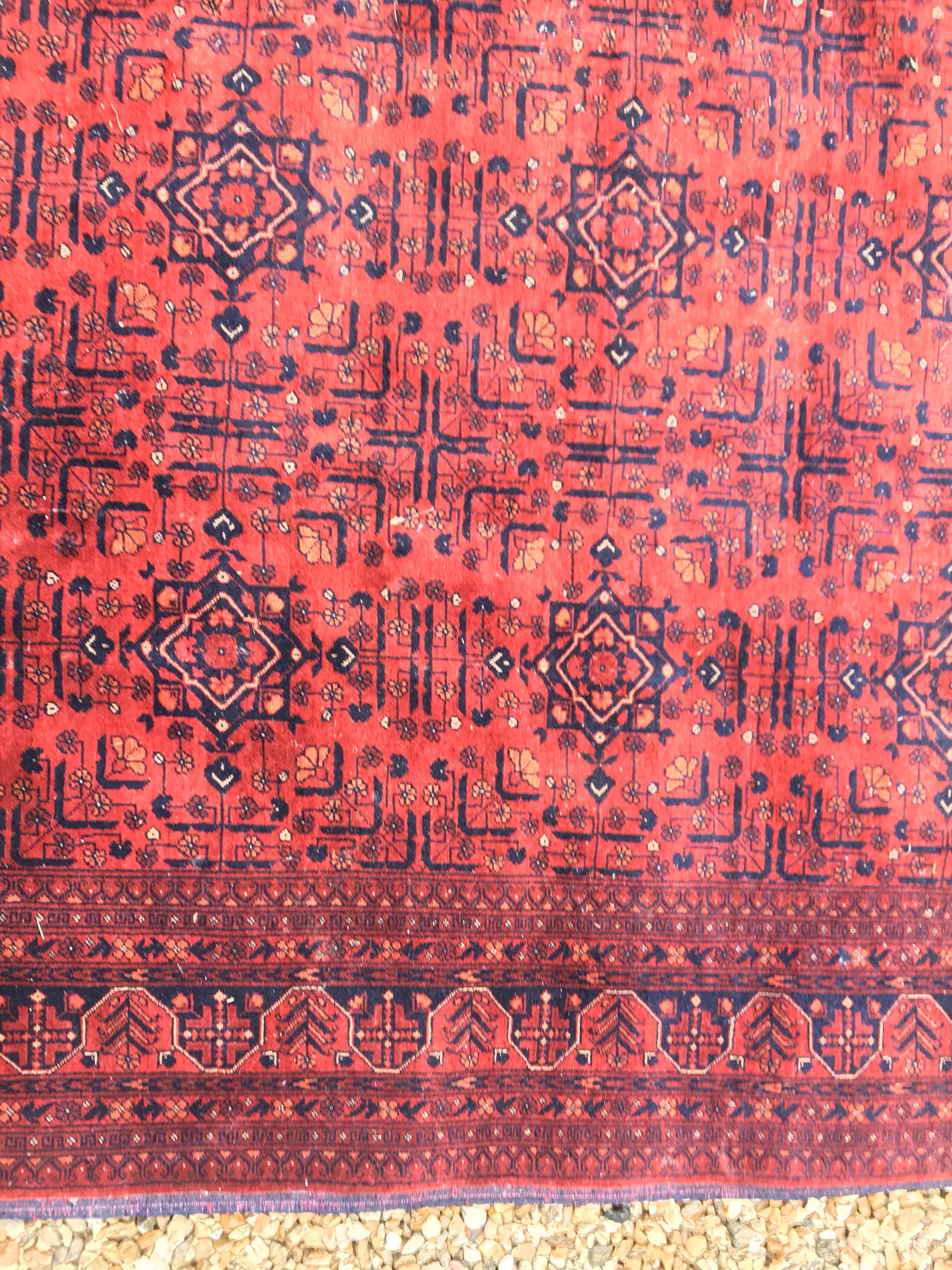 A Bokhara type carpet, the central panel set with repeating medallions on a dark red and black - Image 15 of 23