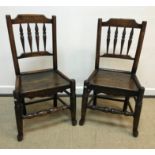 A pair of 19th Century North Country oak spindle back panel seat chairs on turned legs united by