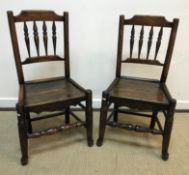 A pair of 19th Century North Country oak spindle back panel seat chairs on turned legs united by