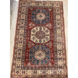 A modern Persian rug, the central panel set with three repeating medallions on a red ground,