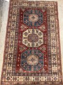 A modern Persian rug, the central panel set with three repeating medallions on a red ground,