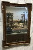 An 18th Century walnut and parcel gilt framed wall mirror of rectangular form with inset edging