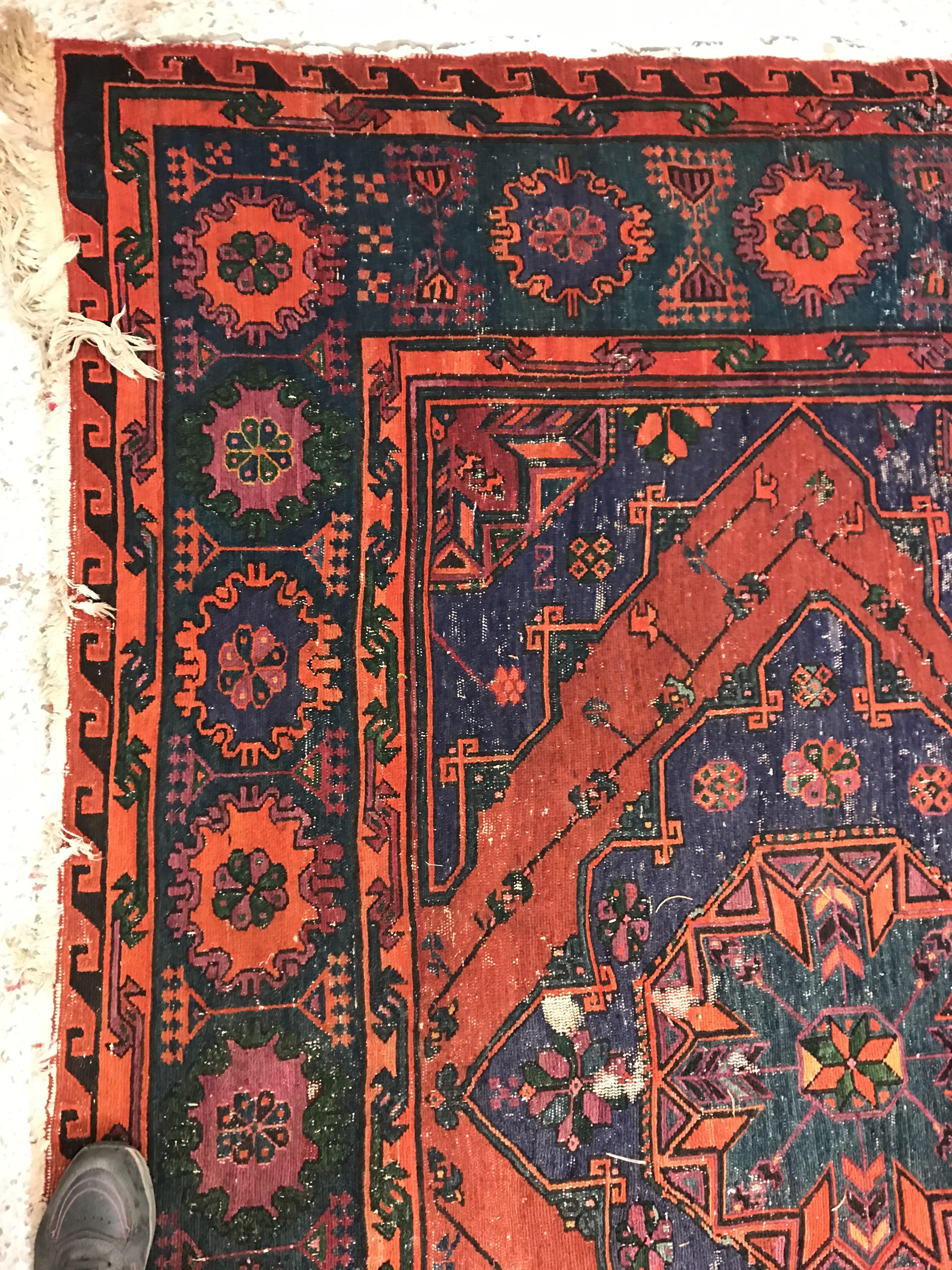 A Persian rug with three repeating lozenge medallions on a red and blue ground, within a blue, red - Image 3 of 20