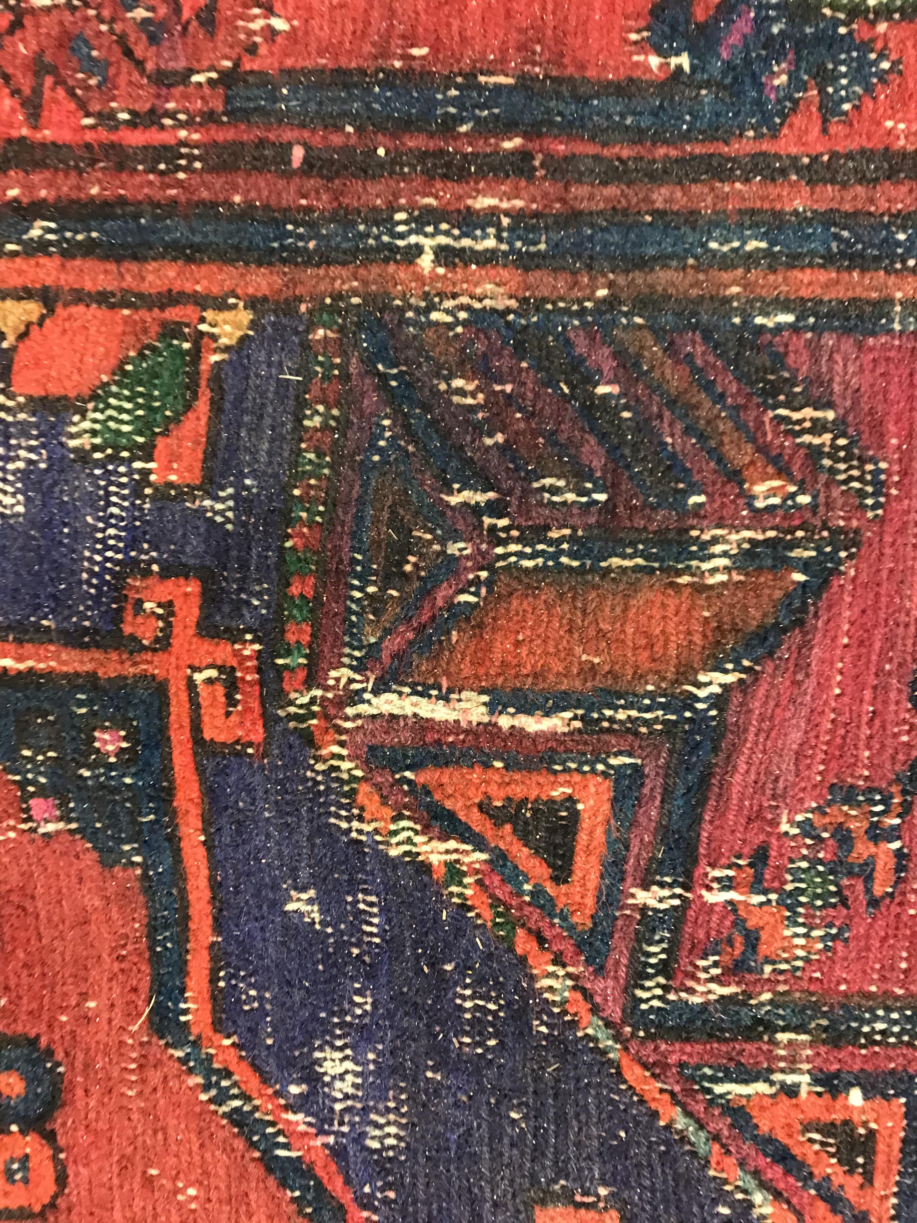 A Persian rug with three repeating lozenge medallions on a red and blue ground, within a blue, red - Image 12 of 20