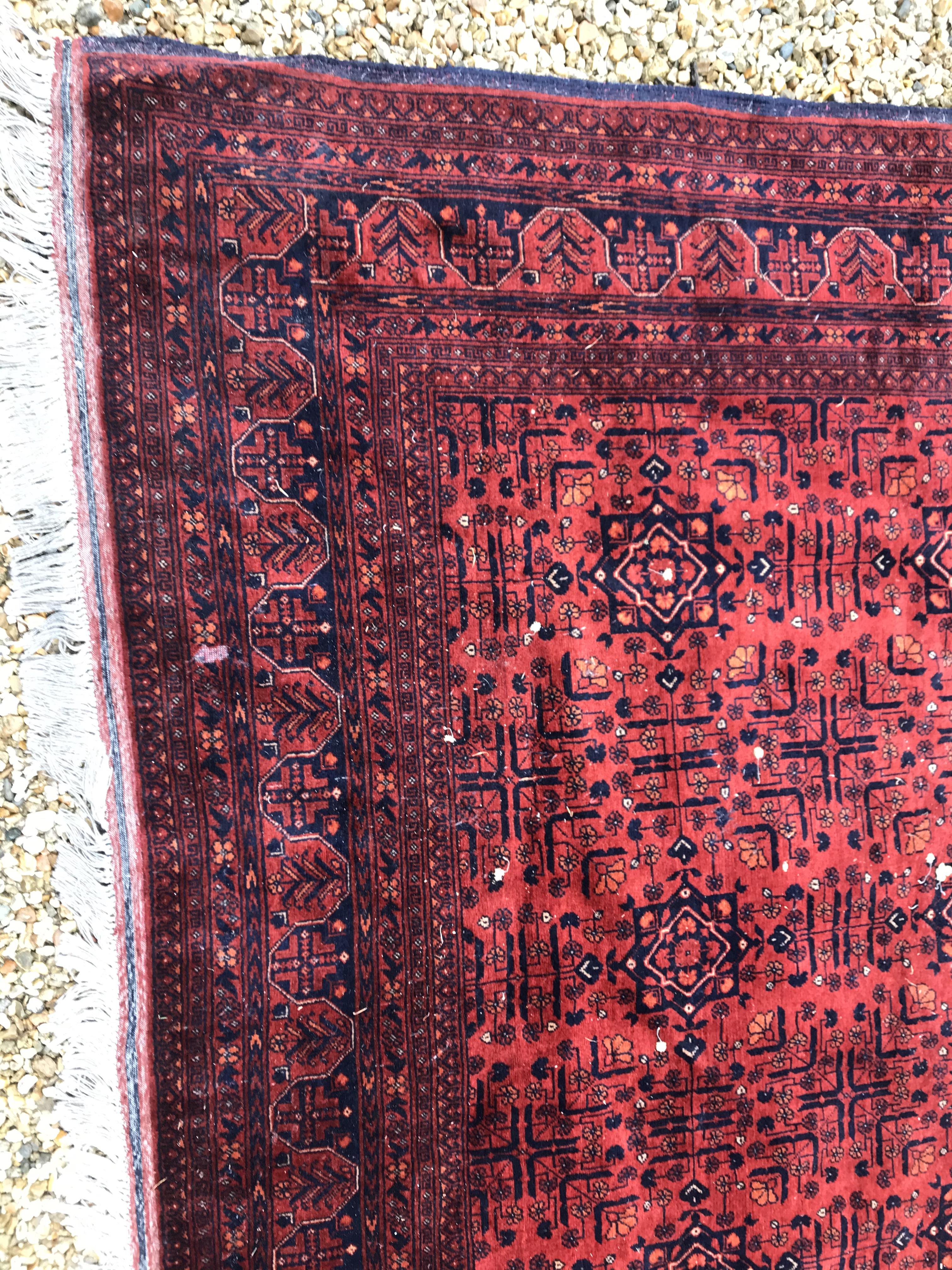 A Bokhara type carpet, the central panel set with repeating medallions on a dark red and black - Image 5 of 23