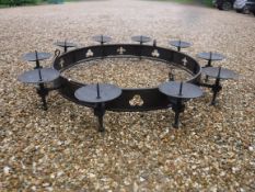 A modern wrought iron hanging ceiling light in the Gothic style with ten pricket candle holders
